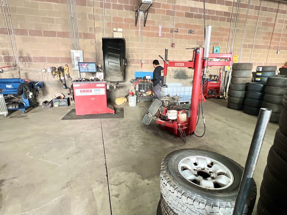 Technician working with a professional Coats tire changer and balancer